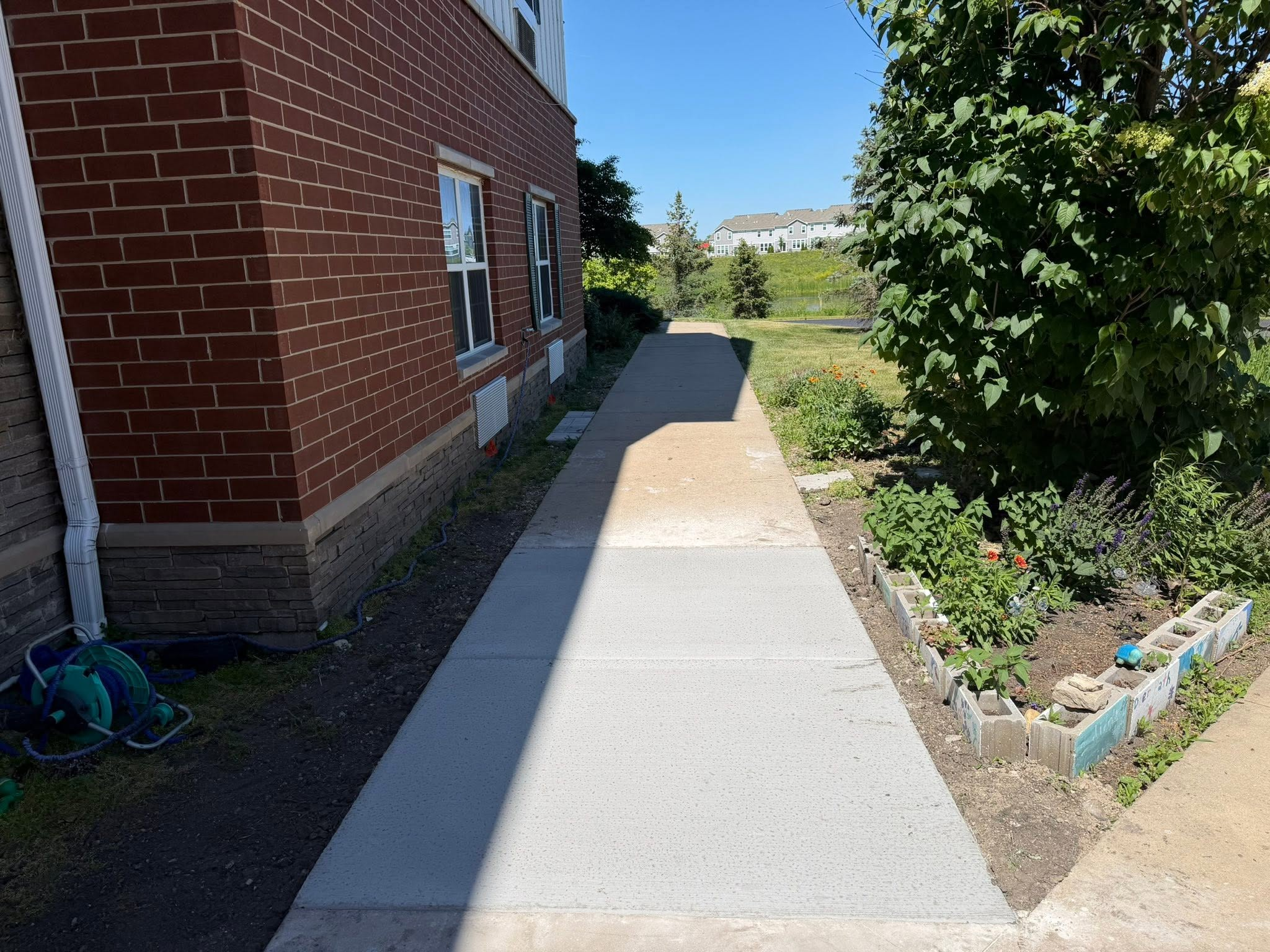 New concrete sidewalk running alongside a brick building